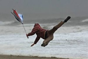 person on a beach being blown in the air from wind